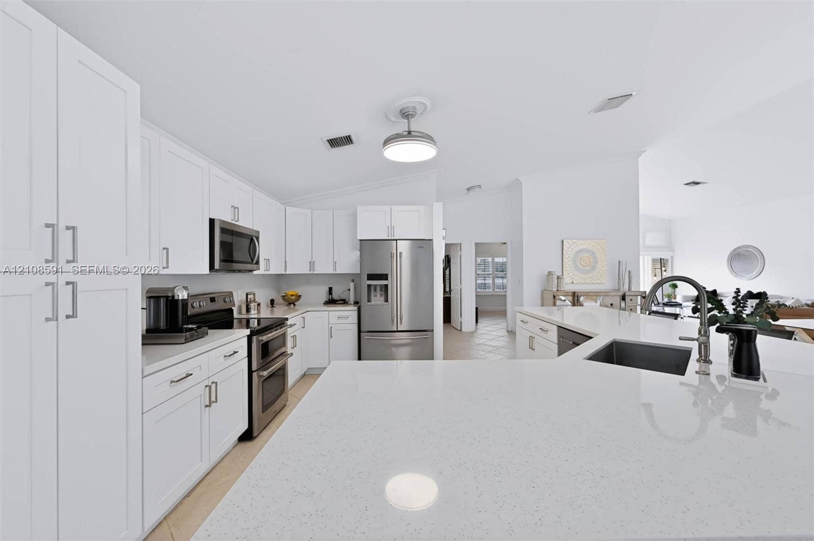 415 SW 200th Terrace, Pembroke Pines, FL 33029 Kitchen featuring white shaker-style cabinetry, a quartz countertop island with an undermount sink, stainless steel appliances, and a modern ceiling-mounted light fixture
