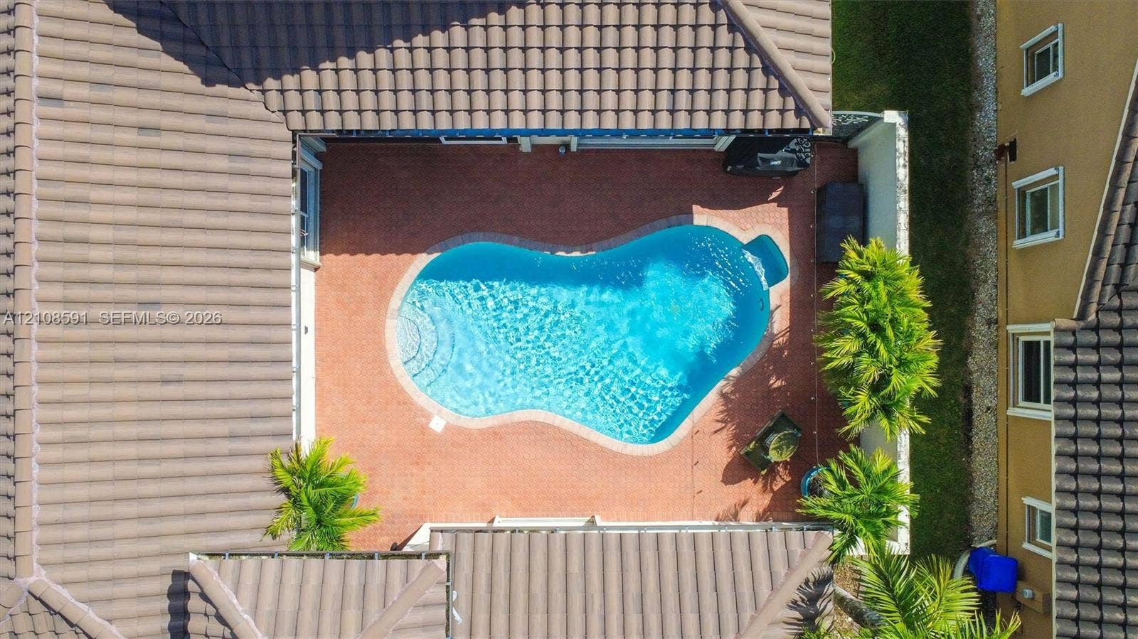 415 SW 200th Terrace, Pembroke Pines, FL 33029 Courtyard featuring a free-form swimming pool, paved patio, and tiled roof structure