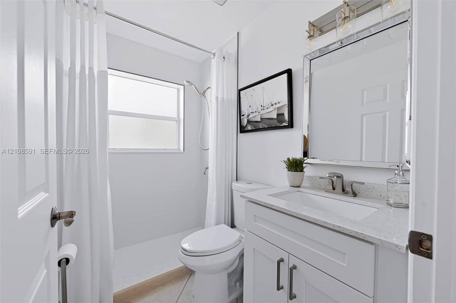 415 SW 200th Terrace, Pembroke Pines, FL 33029 Bathroom featuring a vanity with white cabinetry, a light-toned stone countertop, an integrated rectangular sink, a framed mirror with integrated lighting, and a shower with a handheld fixture