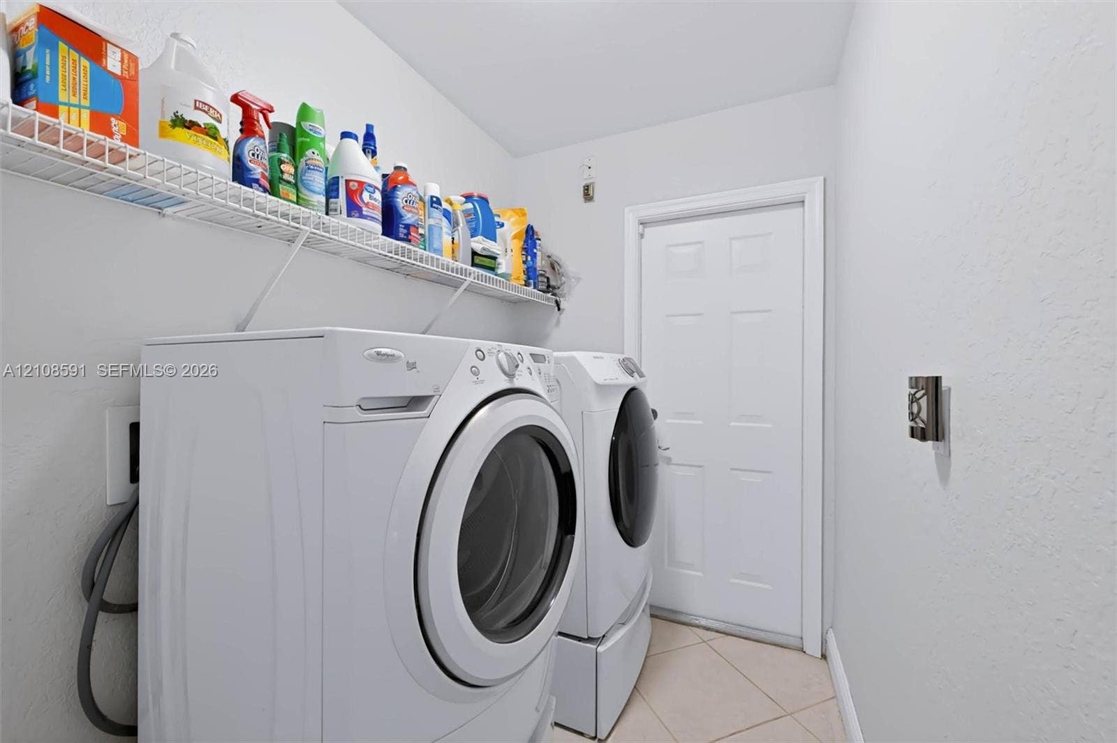 415 SW 200th Terrace, Pembroke Pines, FL 33029 Utility area featuring ceramic tile flooring, a six-panel door, and white wire wall-mounted shelving