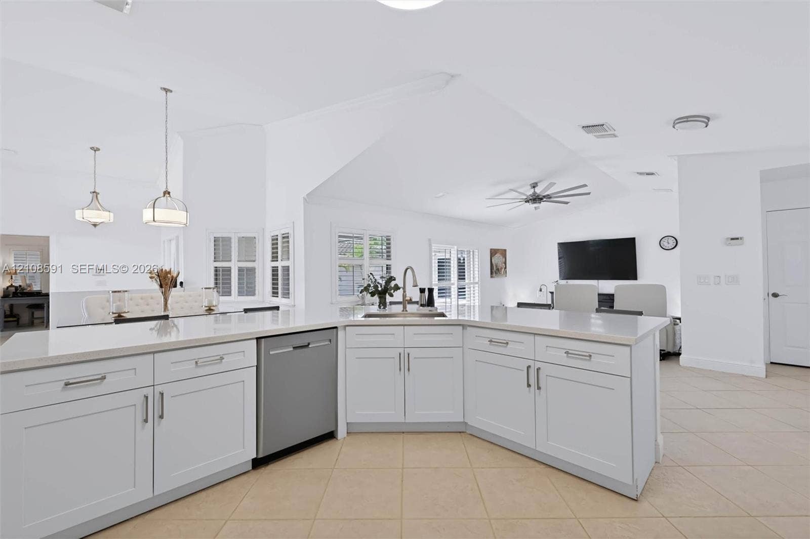 415 SW 200th Terrace, Pembroke Pines, FL 33029 Kitchen featuring a central island with a stone-surface countertop, stainless steel dishwasher, undermount sink, shaker-style cabinetry, and pendant lighting