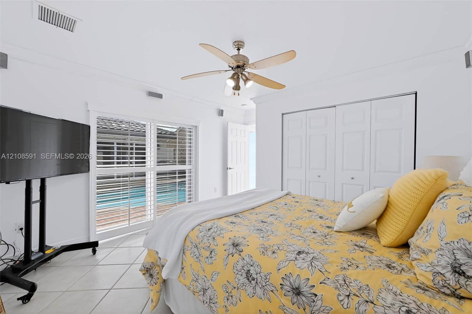 415 SW 200th Terrace, Pembroke Pines, FL 33029 Interior featuring tile flooring, ceiling fan with integrated lighting, multi-panel closet doors, and sliding glass doors with plantation shutters