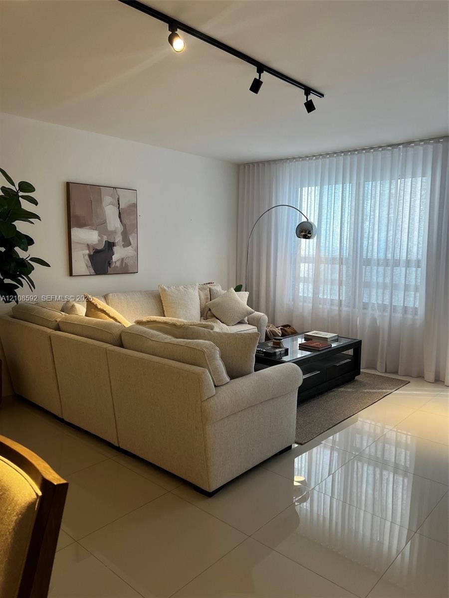 10185 Collins Avenue, #515, Bal Harbour, Bal Harbour, FL 33154 Polished tile flooring, black track lighting, and floor-to-ceiling sheer window treatments