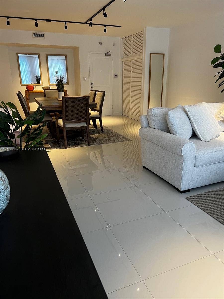 10185 Collins Avenue, #515, Bal Harbour, Bal Harbour, FL 33154 Large-format polished tile flooring, black track lighting system, and floor-to-ceiling louvered closet doors