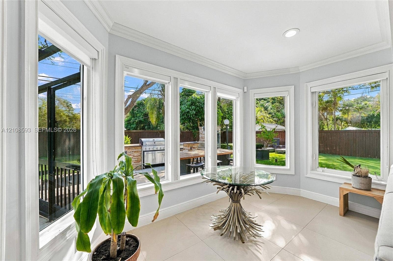 8230 SW 151st Street, Palmetto Bay, FL 33158 Sunroom featuring large paneled windows, neutral tile flooring, crown molding, and recessed lighting