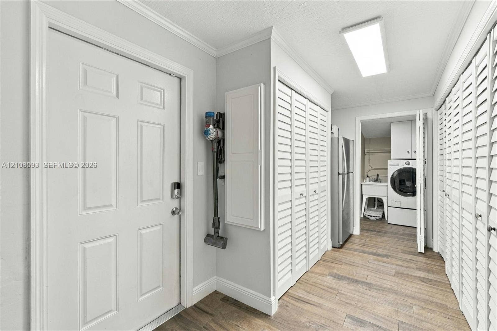 8230 SW 151st Street, Palmetto Bay, FL 33158 Utility area featuring wood-finish flooring, dual sets of louvered closet doors, and recessed lighting
