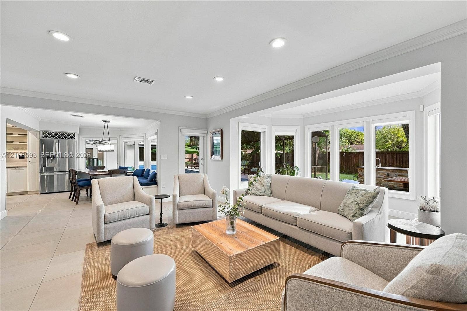 8230 SW 151st Street, Palmetto Bay, FL 33158 Open-concept space featuring oversized bay windows, neutral tile flooring, recessed lighting, and crown molding