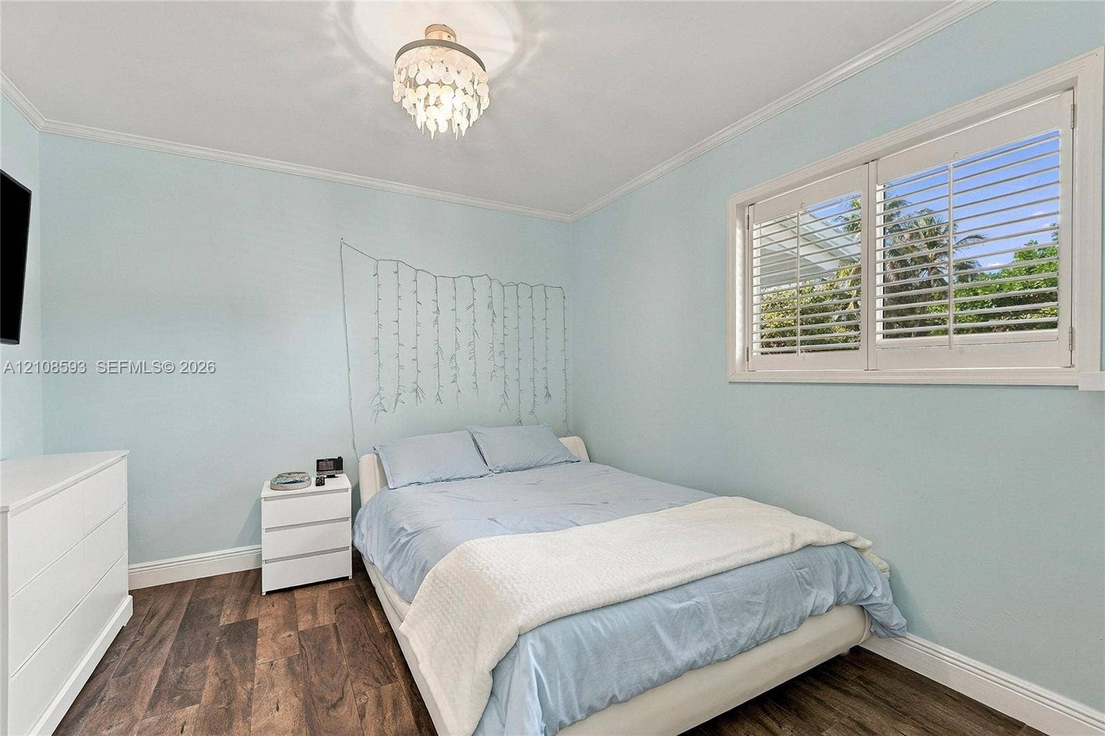 8230 SW 151st Street, Palmetto Bay, FL 33158 Room featuring wood-finish flooring, plantation shutters, and a decorative chandelier
