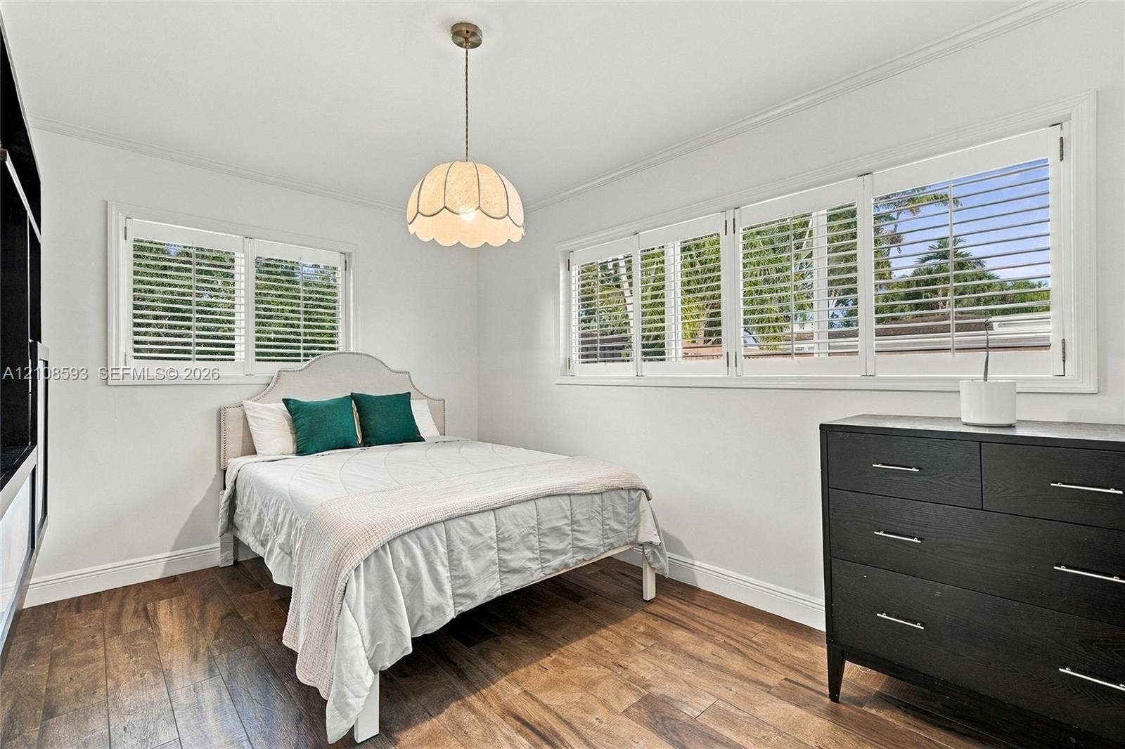 8230 SW 151st Street, Palmetto Bay, FL 33158 Wood-finish flooring, multi-pane windows with integrated shutters, and a scalloped glass pendant light fixture