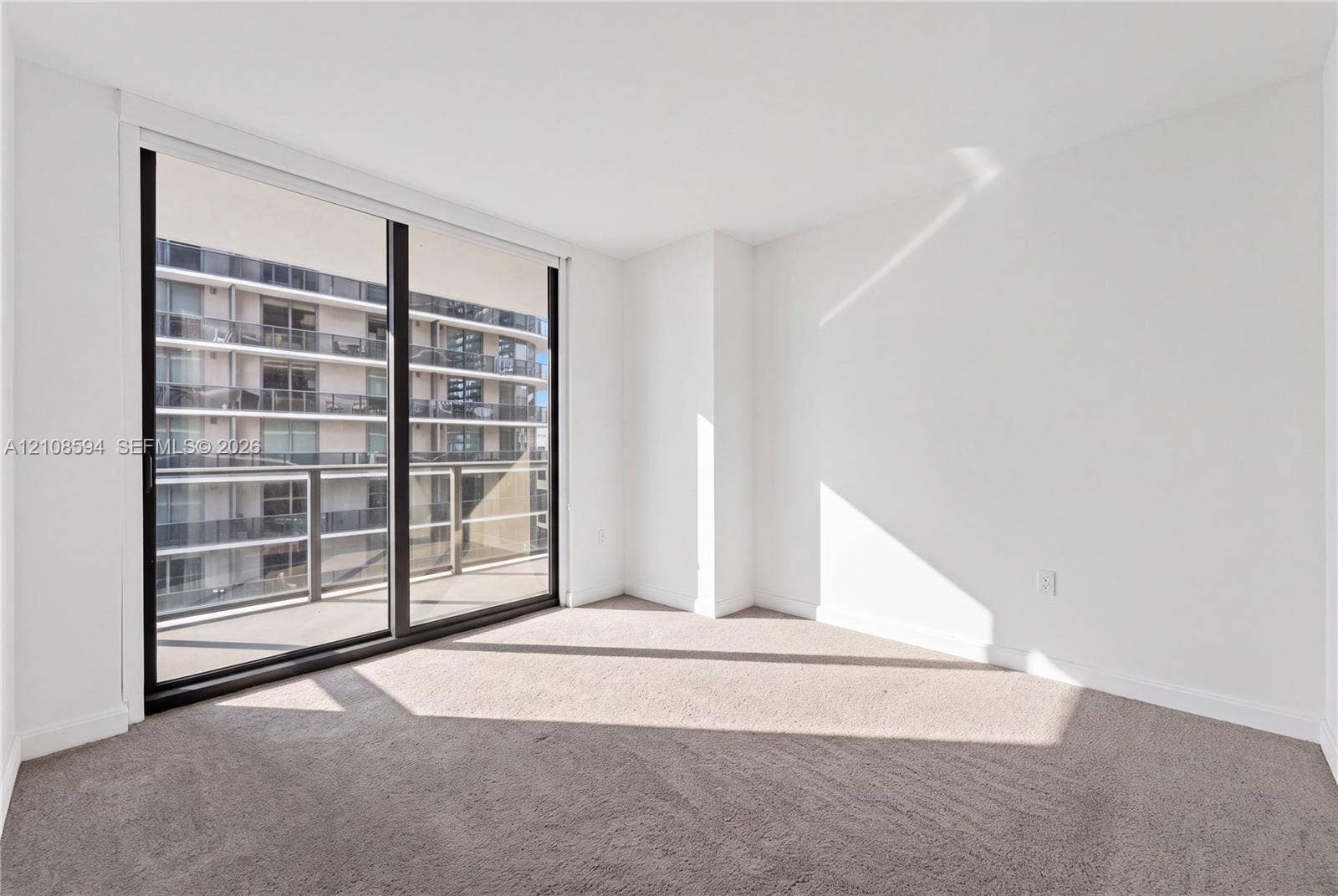 45 SW 9th Street, #2206, Miami, FL 33130 Full-height sliding glass door, neutral carpeting, and private balcony access
