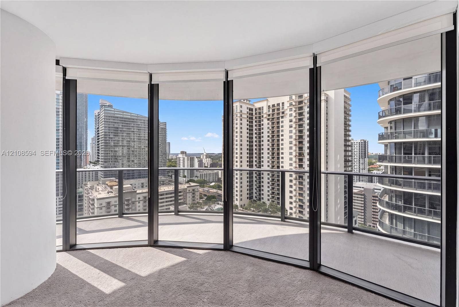 45 SW 9th Street, #2206, Miami, FL 33130 Curved balcony with glass railing, floor-to-ceiling windows, and wall-to-wall carpeting