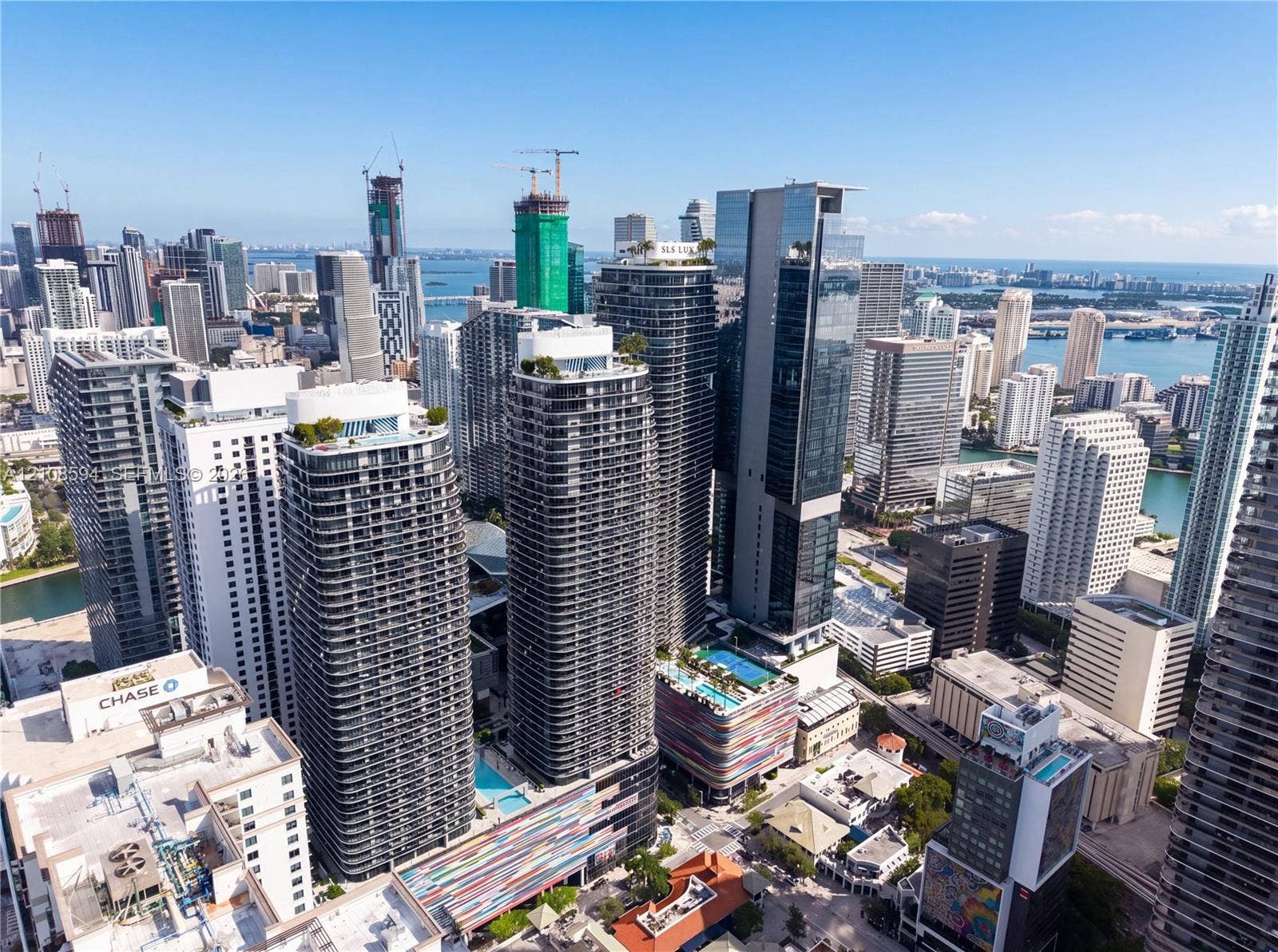 45 SW 9th Street, #2206, Miami, FL 33130 High-rise urban landscape featuring contemporary skyscrapers, glass-facade architecture, rooftop outdoor swimming pools, and proximity to coastal waters