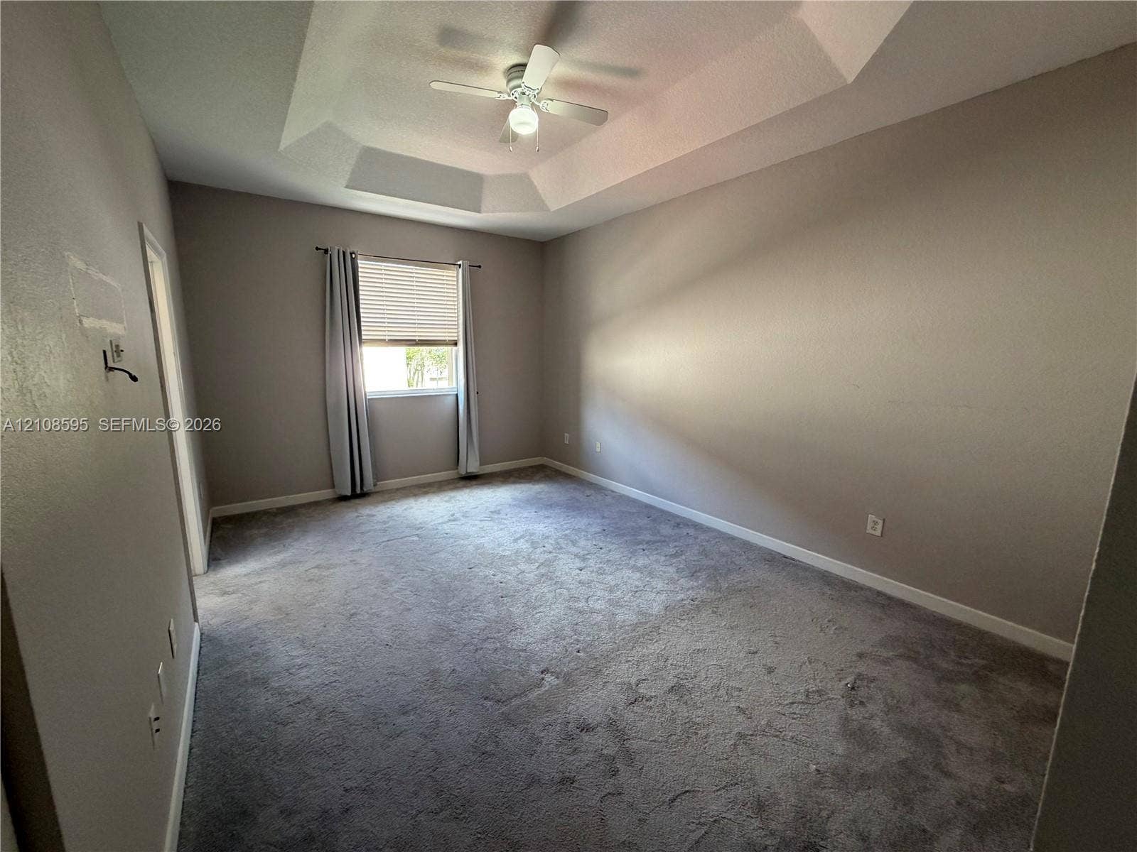 12989 SW 135th Terrace, #0, Miami, Miami, FL 33186 Tray ceiling with a central ceiling fan and neutral wall finish, complemented by wall-to-wall carpeting and an operable window