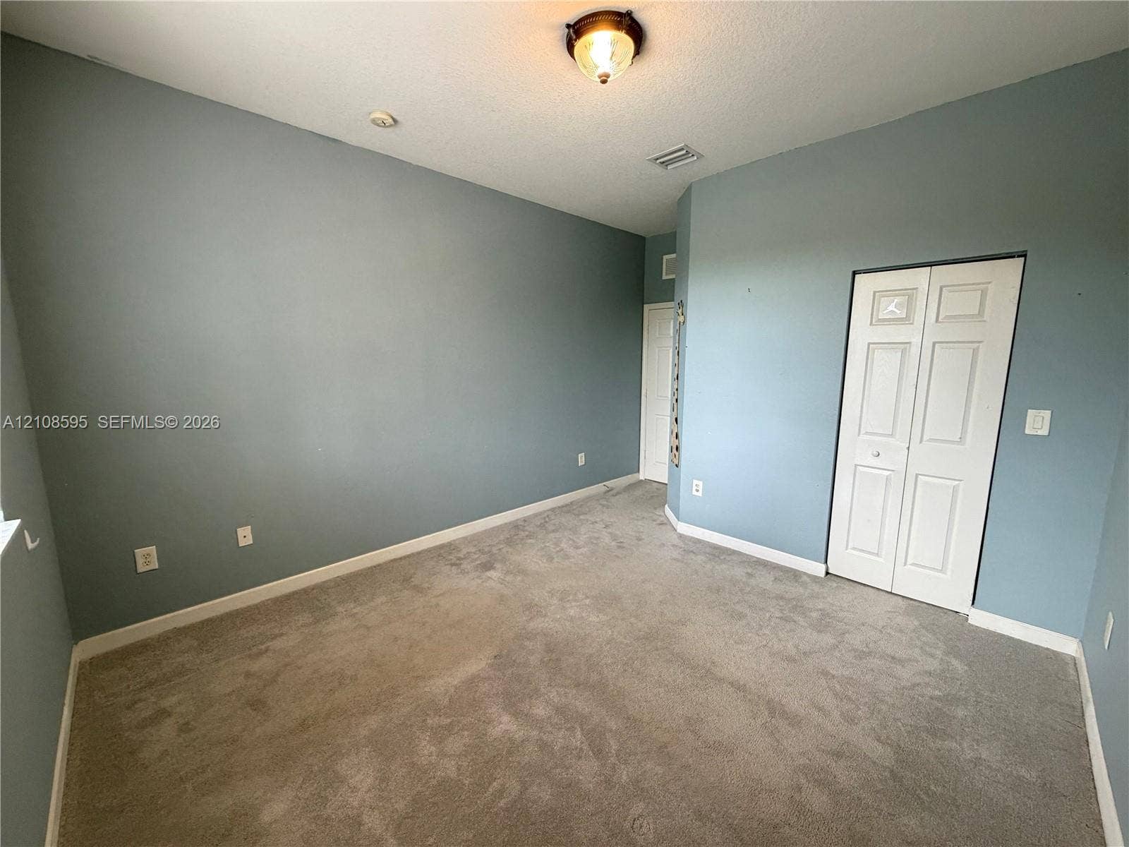 12989 SW 135th Terrace, #0, Miami, Miami, FL 33186 Room featuring neutral wall-to-wall carpeting, flush-mount lighting, and a bi-fold closet door