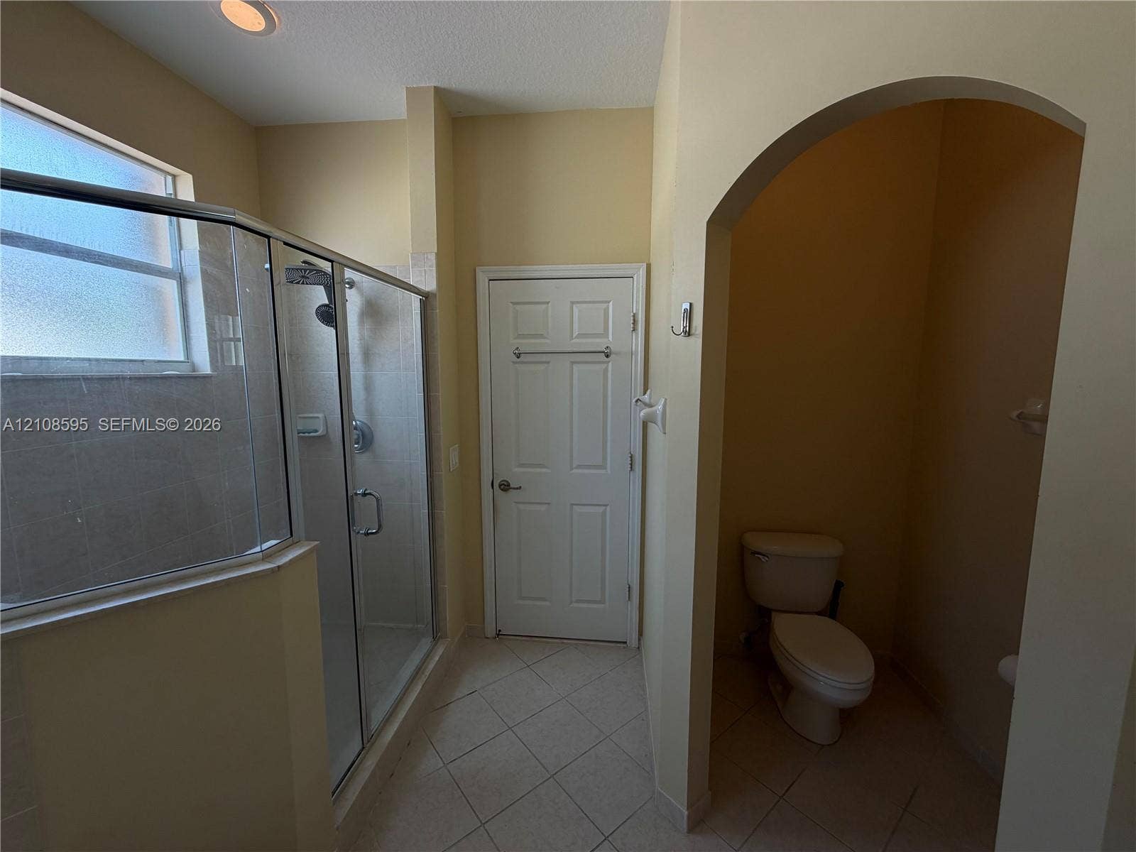 12989 SW 135th Terrace, #0, Miami, Miami, FL 33186 Walk-in glass shower enclosure, arched entryway to water closet, tile flooring, and recessed ceiling lighting