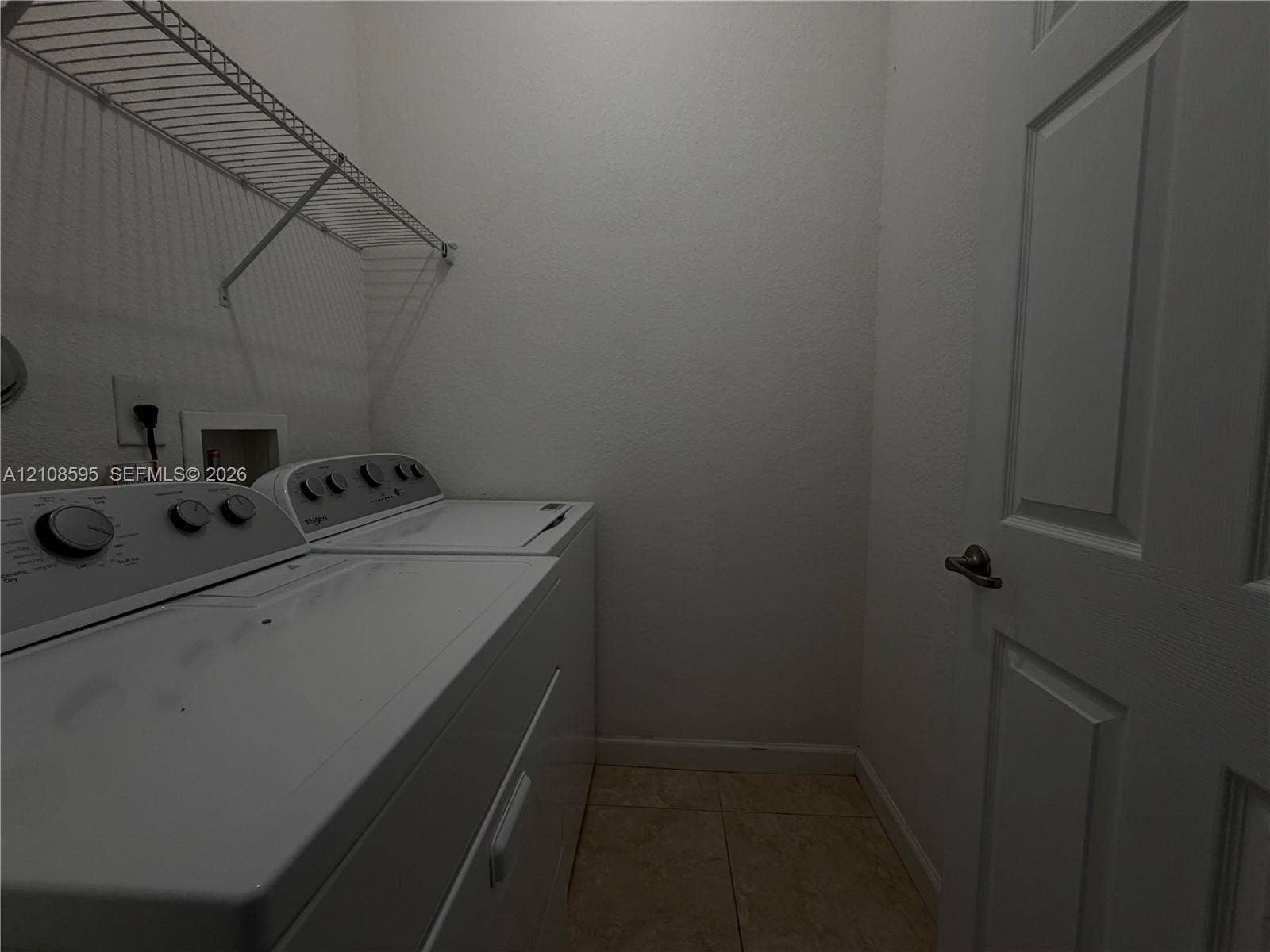 12989 SW 135th Terrace, #0, Miami, Miami, FL 33186 Laundry area featuring tile flooring, a six-panel door, and integrated wall-mounted wire shelving