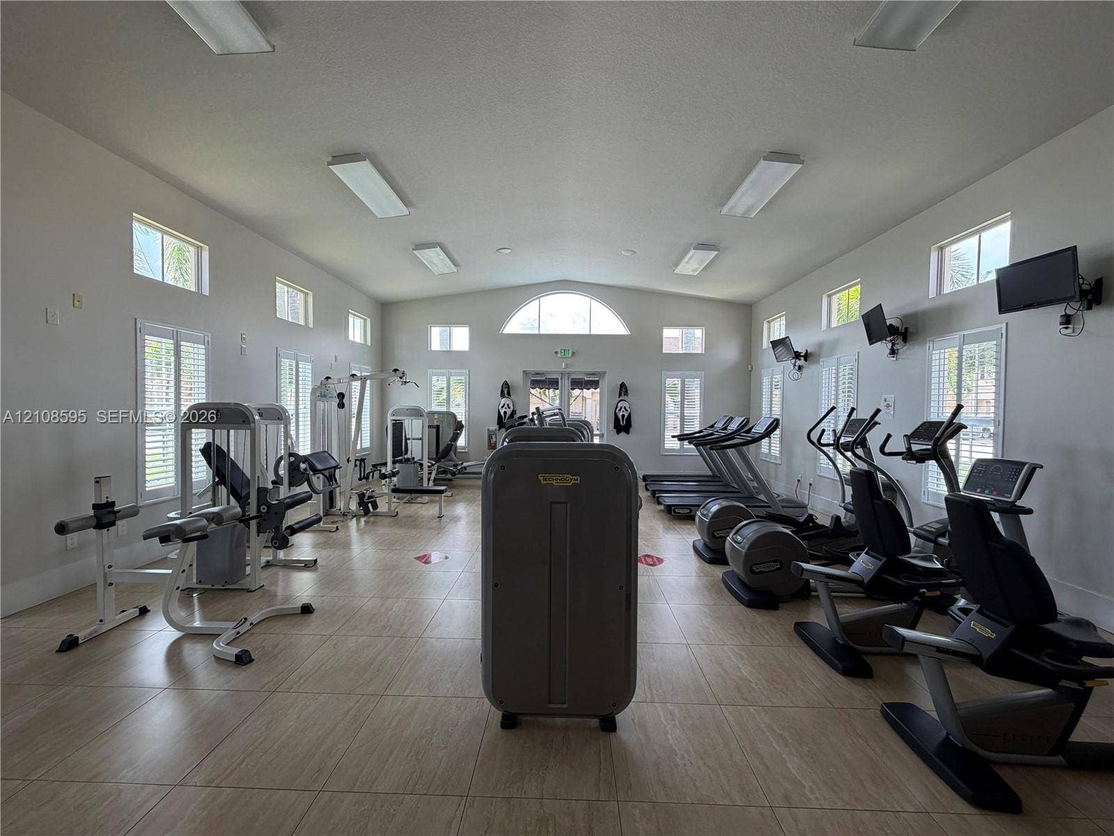 12989 SW 135th Terrace, #0, Miami, Miami, FL 33186 Fitness center featuring tile flooring, multi-pane windows with plantation shutters, vaulted ceilings, and recessed lighting