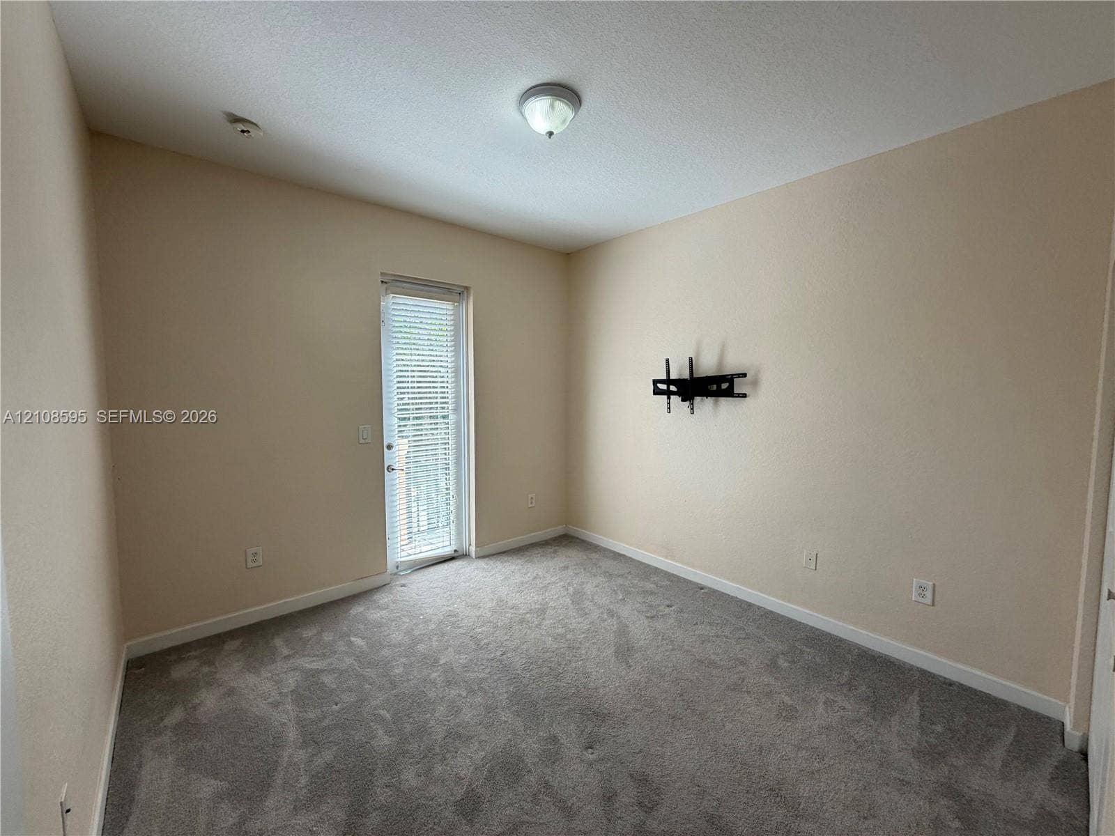 12989 SW 135th Terrace, #0, Miami, Miami, FL 33186 Room featuring wall-to-wall carpeting, neutral paint, a single-light flush mount ceiling fixture, and a glass-paneled door with integrated blinds