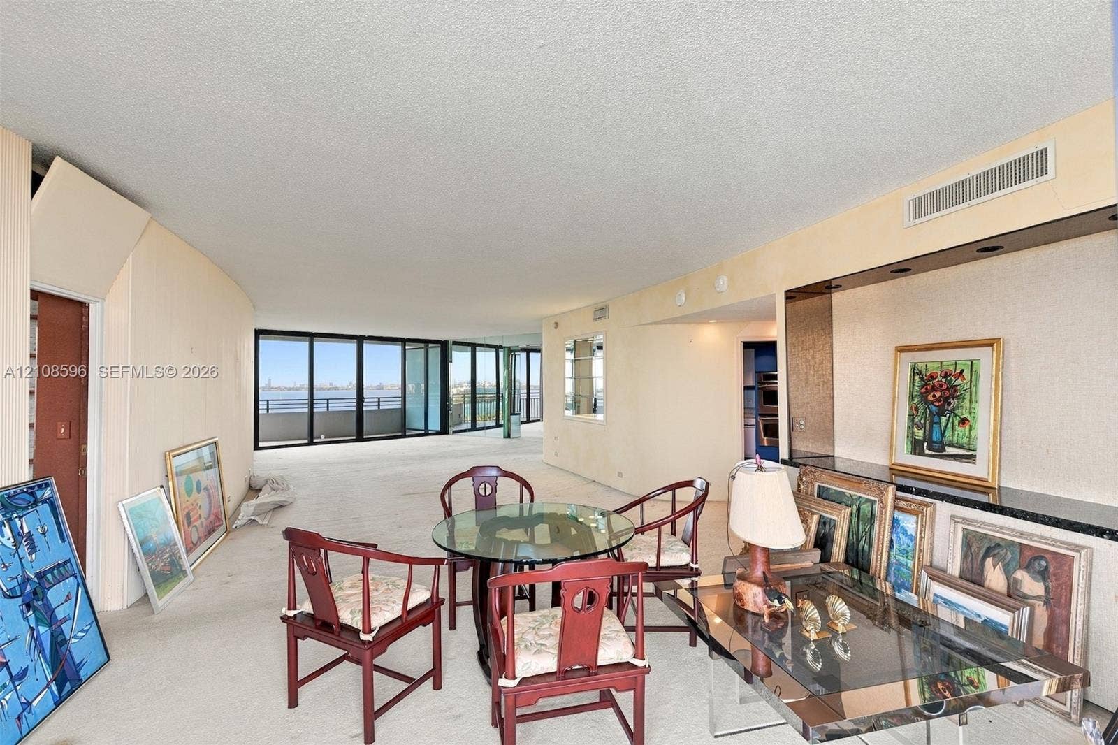 Expansive living space featuring floor-to-ceiling glass doors, wall-to-wall carpeting, and a built-in recessed storage niche with a stone-surfaced ledge