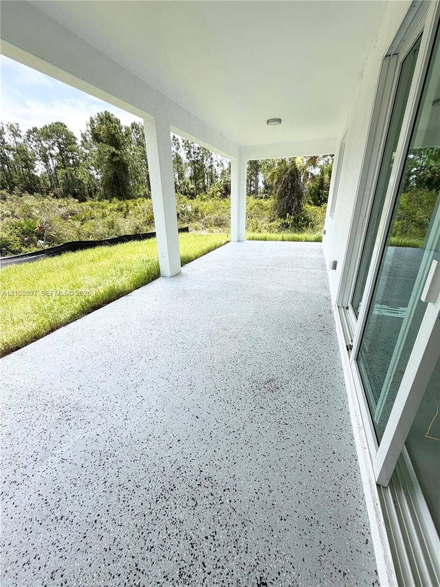 808 Congress Avenue, Lehigh Acres, FL 33972 Covered concrete patio featuring a speckled finish, support columns, and sliding glass door access