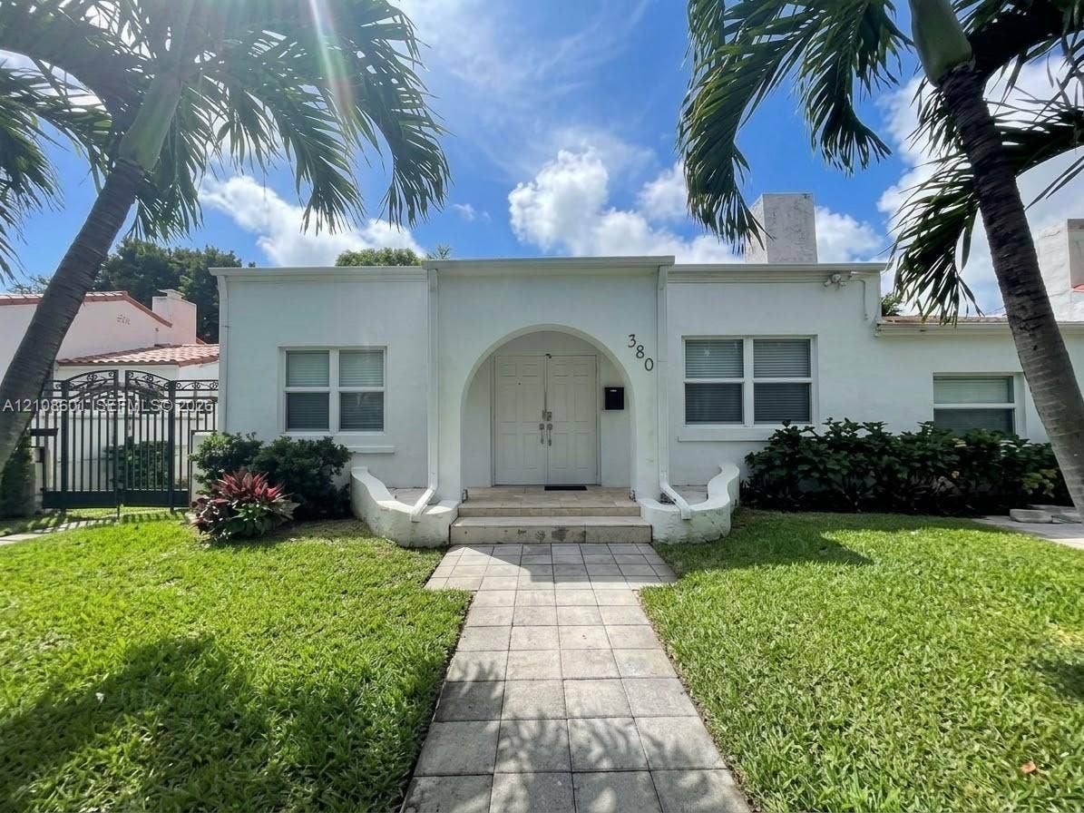 552 NE 74th Street, #0, Miami, Miami, FL 33138 Stucco exterior featuring an arched entryway, double-door entrance, stone-paved walkway, and manicured landscaping
