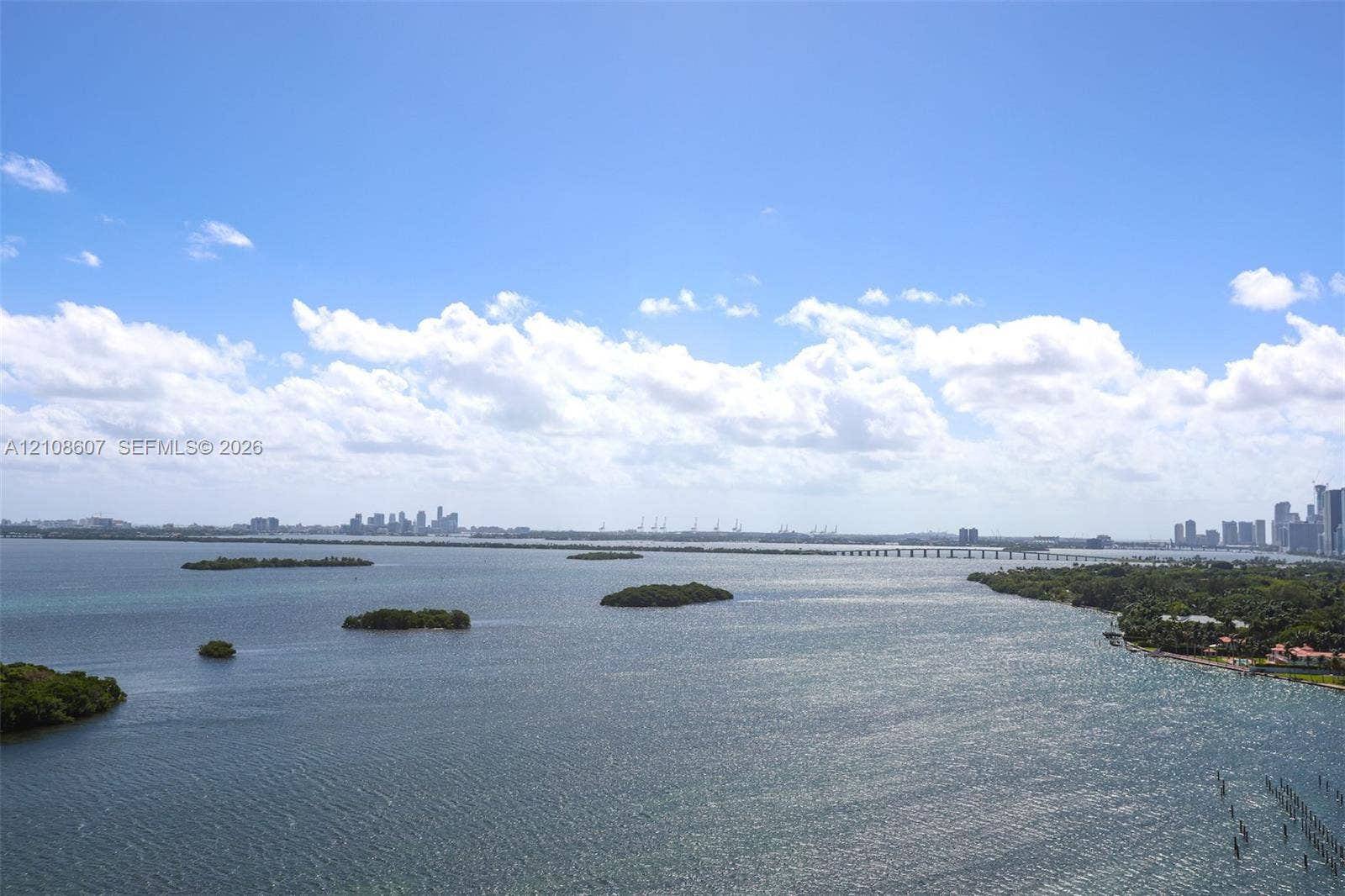 Panoramic bay waterscape featuring coastal islands, distant cityscape skyline, and bridge infrastructure