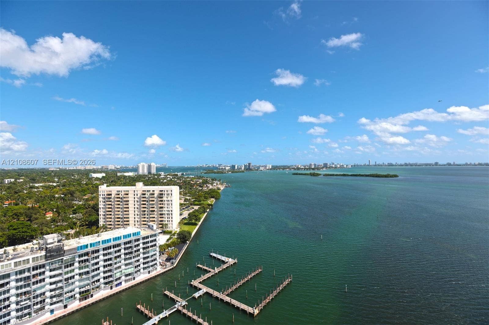 Elevated waterfront perspective featuring expansive coastal scenery, deep-water bay access, and a multi-slip private dock structure