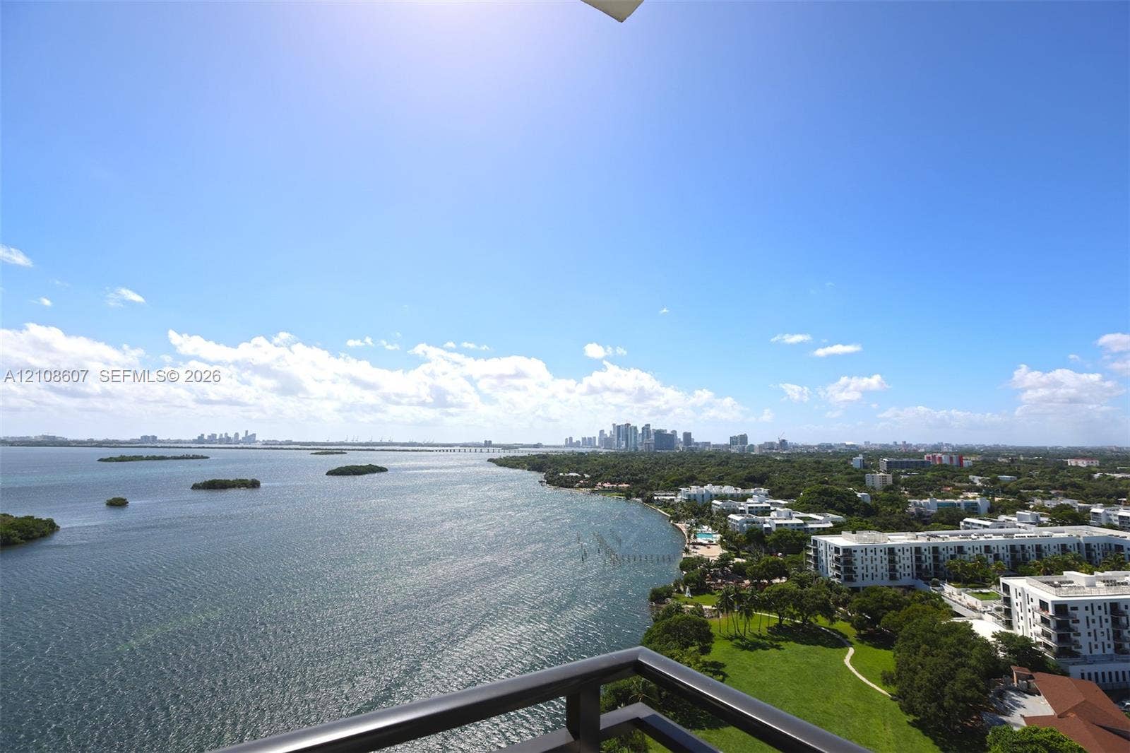 Elevated balcony featuring a metal railing with a panoramic perspective of the bay, coastline, and urban skyline