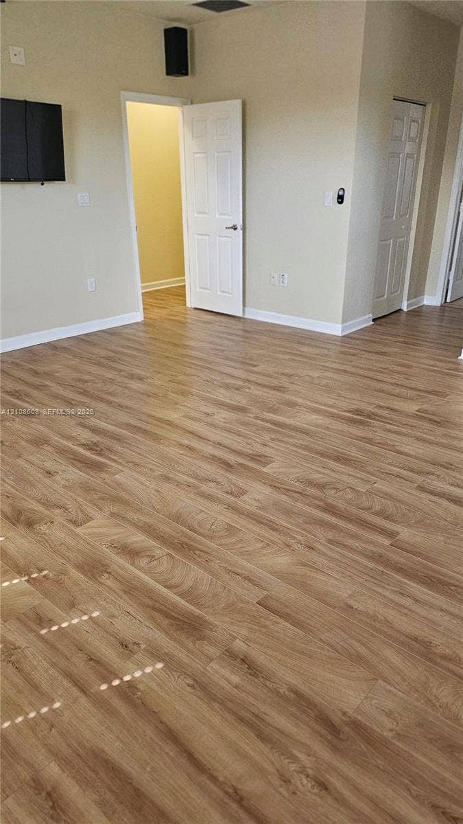 24041 SW 114th Place, Homestead, FL 33032 Interior space featuring wood-finish flooring, neutral wall tones, multi-panel interior doors, and a wall-mounted speaker