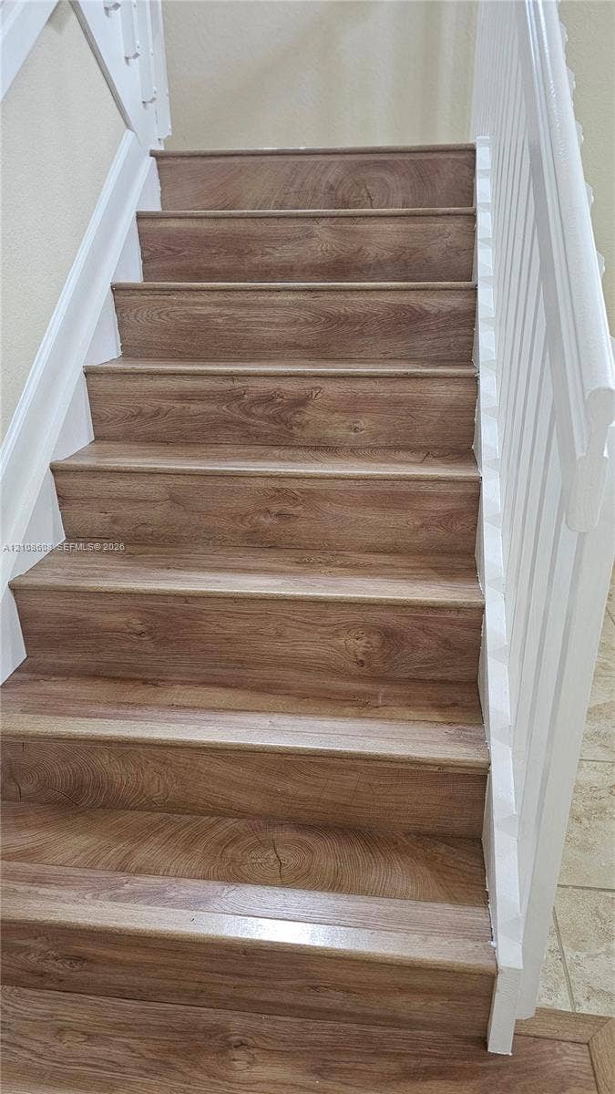 24041 SW 114th Place, Homestead, FL 33032 Staircase featuring wood-finish treads and white-painted railings