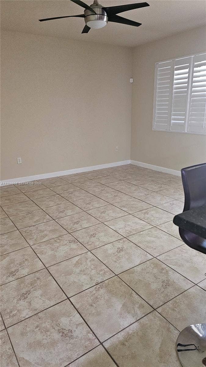 24041 SW 114th Place, Homestead, FL 33032 Interior space featuring large-format ceramic tile flooring, plantation shutters, and a multi-blade ceiling fan with integrated lighting