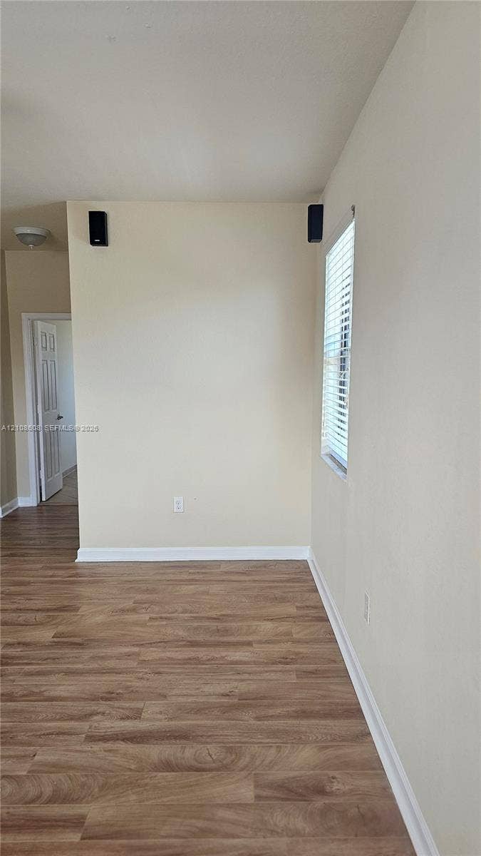 24041 SW 114th Place, Homestead, FL 33032 Interior space featuring wood-finish flooring, a neutral wall palette, and a window with horizontal blinds