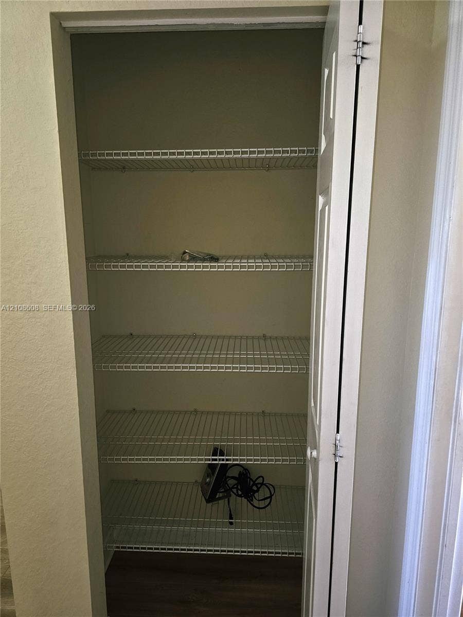 24041 SW 114th Place, Homestead, FL 33032 Storage closet featuring five tiers of white wire shelving and a hinged six-panel door