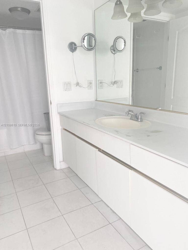 1900 Sunset Harbour Drive, #1210, Miami Beach, Miami Beach, FL 33139 Bathroom featuring a white vanity with a solid surface countertop, an integrated sink, dual wall-mounted magnifying mirrors, a large wall-to-wall mirror, and ceramic tile flooring