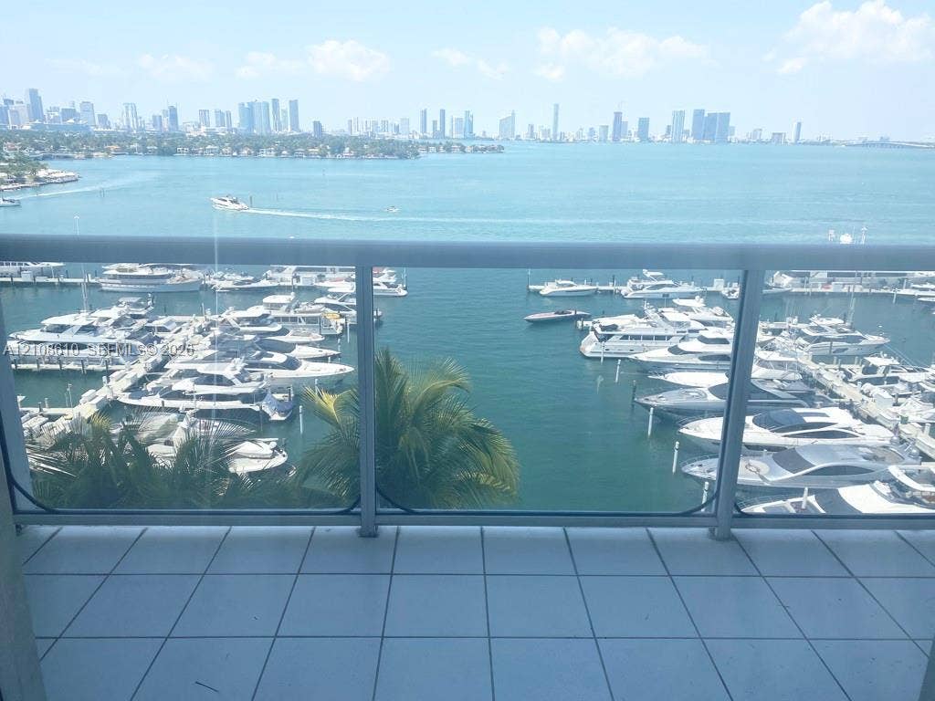 1900 Sunset Harbour Drive, #1210, Miami Beach, Miami Beach, FL 33139 Private balcony featuring white tile flooring and a glass-paneled railing, overlooking a marina and city skyline