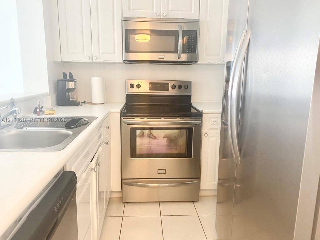 1900 Sunset Harbour Drive, #1210, Miami Beach, Miami Beach, FL 33139 Kitchen featuring white cabinetry, stainless steel appliances, a glass-top electric range, a built-in microwave, and tile flooring