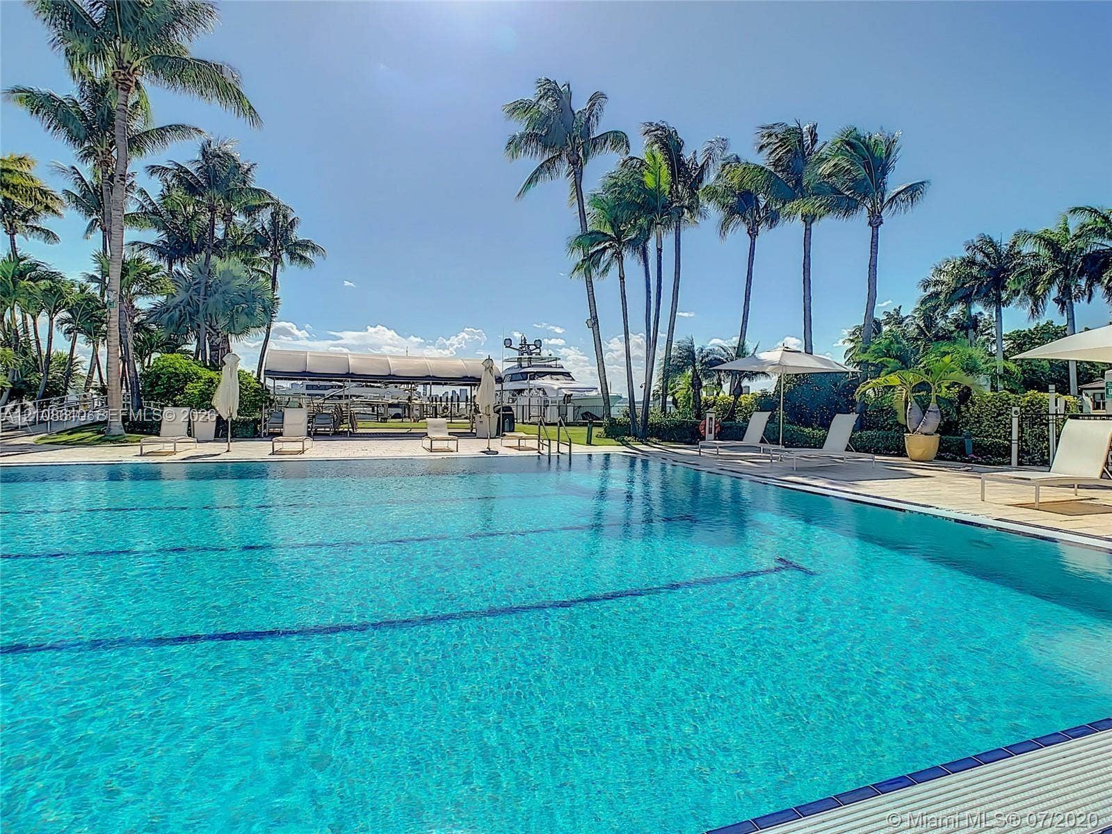 1900 Sunset Harbour Drive, #1210, Miami Beach, Miami Beach, FL 33139 Swimming pool featuring tiled lane markers, stone-paved deck, covered boat dock, and mature palm trees
