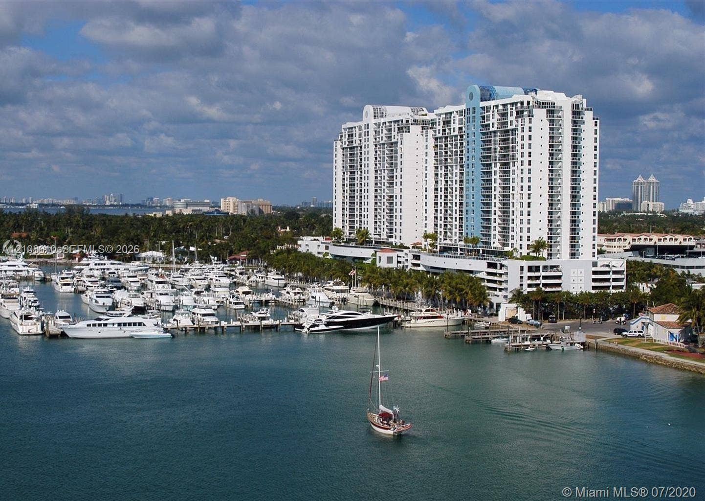 1900 Sunset Harbour Drive, #1210, Miami Beach, Miami Beach, FL 33139 High-rise residential tower featuring multiple tiered balconies, a prominent blue glass facade element, and an integrated multi-level parking structure