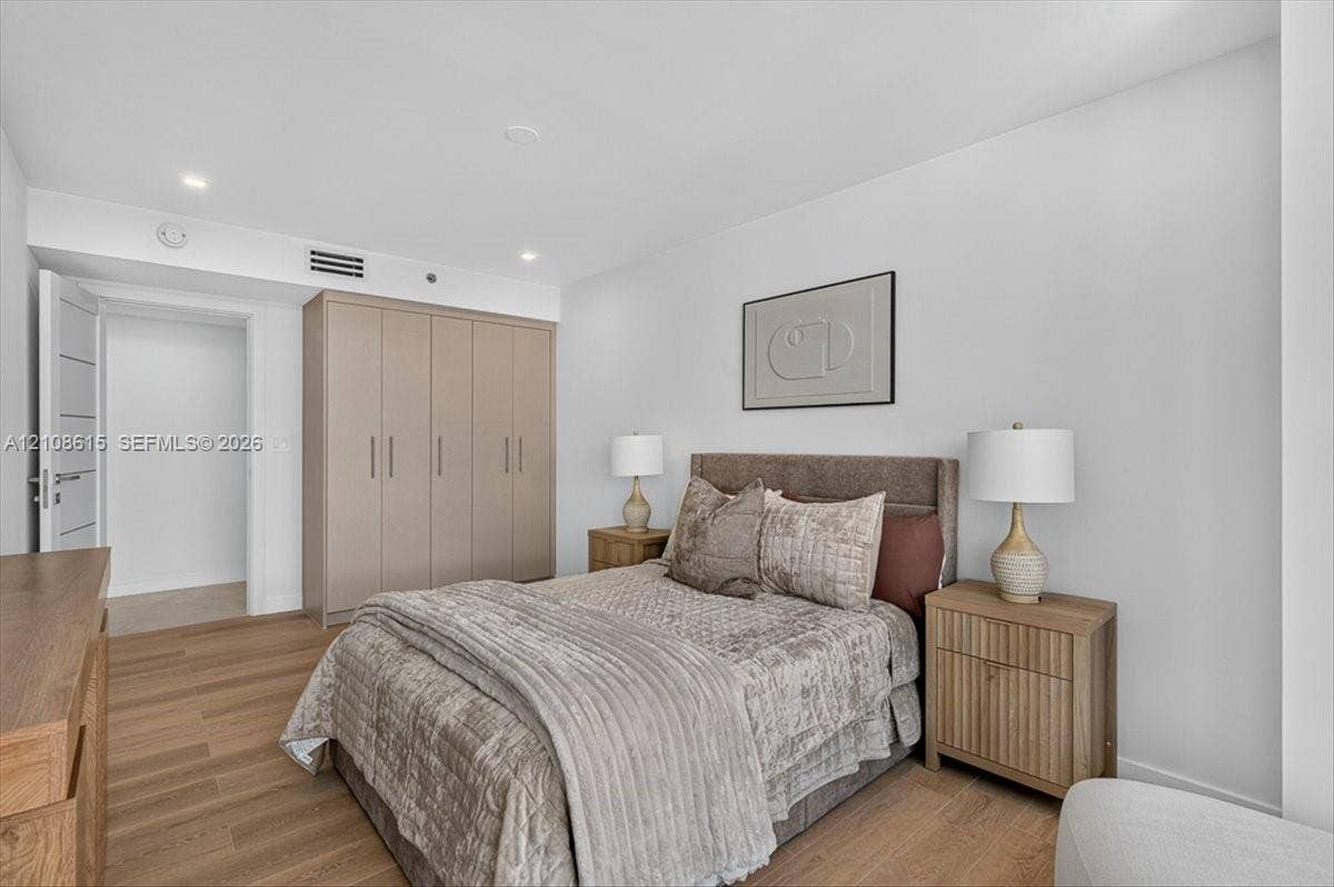 9455 Collins Avenue, #1201, Surfside, FL 33154 Room featuring wood-finish flooring, recessed lighting, and floor-to-ceiling built-in cabinetry with integrated hardware