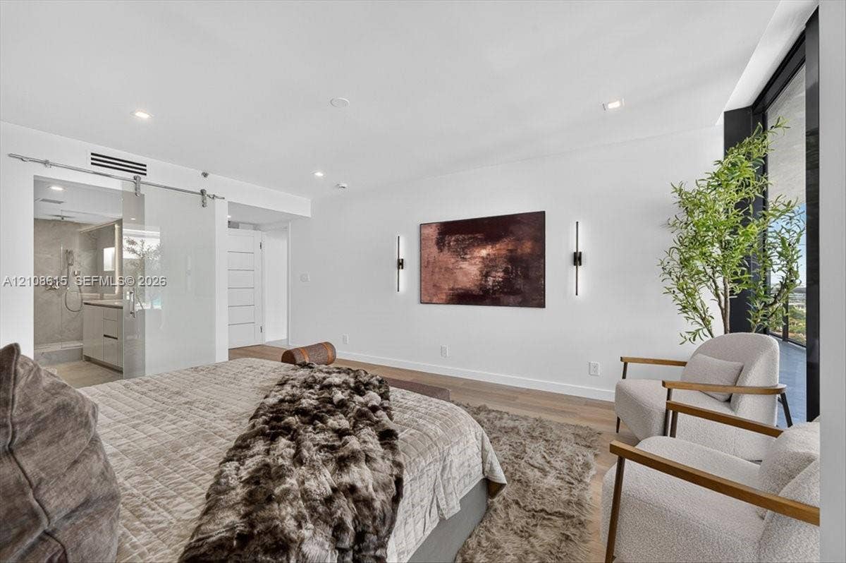 9455 Collins Avenue, #1201, Surfside, FL 33154 Wood-finish flooring, recessed lighting, wall-mounted linear light fixtures, sliding glass door with a metal track system, and floor-to-ceiling windows