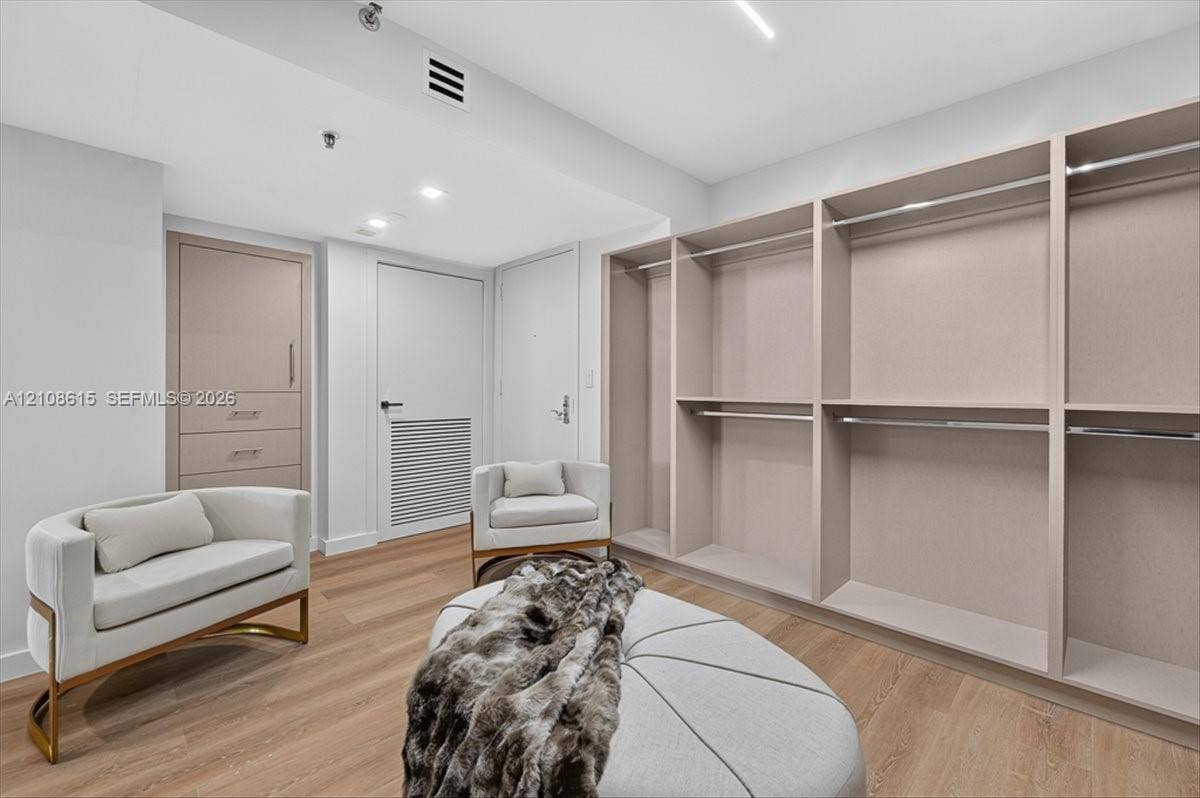 9455 Collins Avenue, #1201, Surfside, FL 33154 Custom built-in storage system featuring light wood-finish shelving and hanging rods, integrated drawer unit with brushed metal hardware, and wood-finish flooring