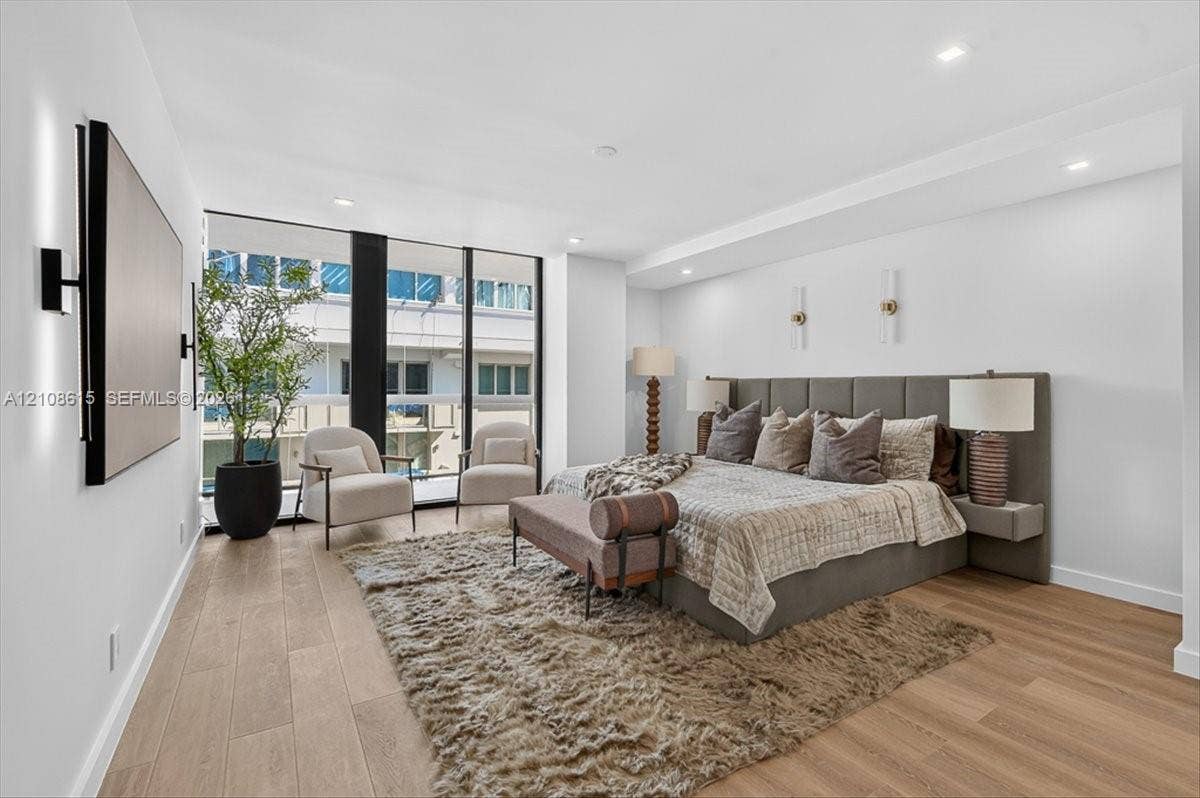 9455 Collins Avenue, #1201, Surfside, FL 33154 Floor-to-ceiling windows, wood-finish flooring, recessed lighting, and wall-mounted light fixtures