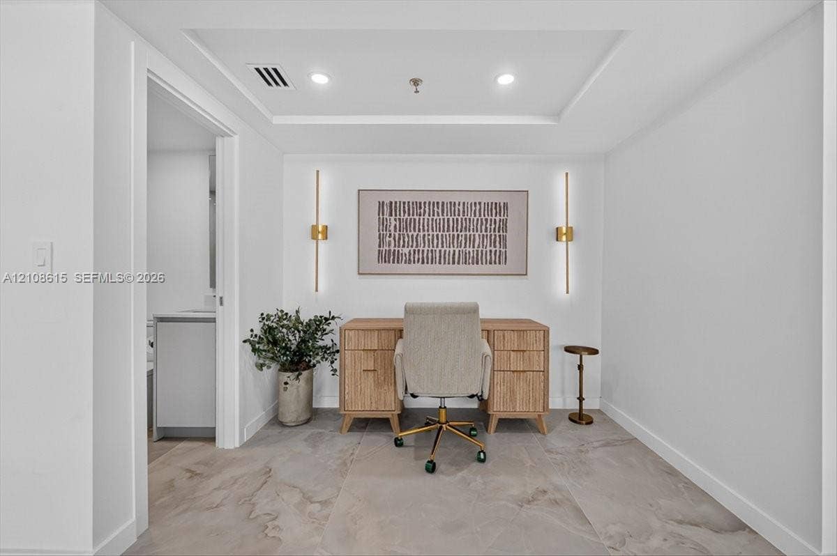 9455 Collins Avenue, #1201, Surfside, FL 33154 Room featuring large-format tile flooring, a recessed tray ceiling, and dual wall-mounted metallic light fixtures