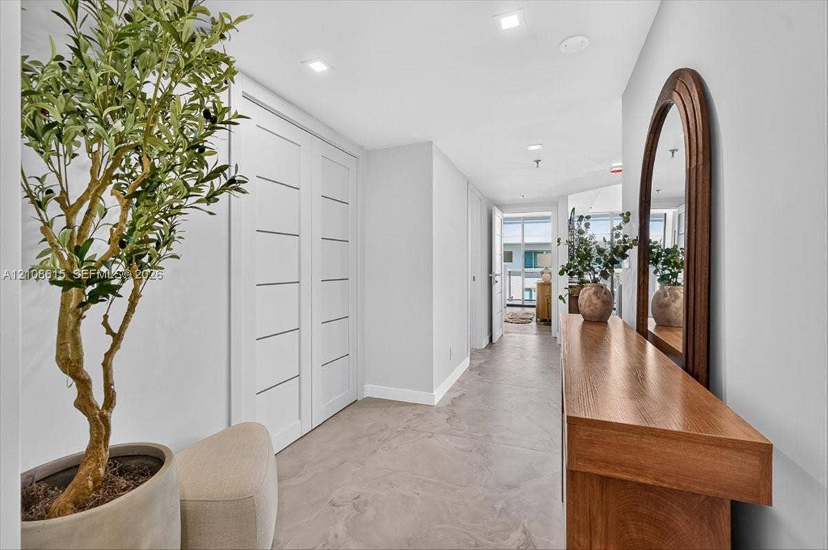 9455 Collins Avenue, #1201, Surfside, FL 33154 Hallway featuring light-toned smooth-finish flooring, recessed ceiling lighting, and crisp white walls with modern multi-panel interior doors