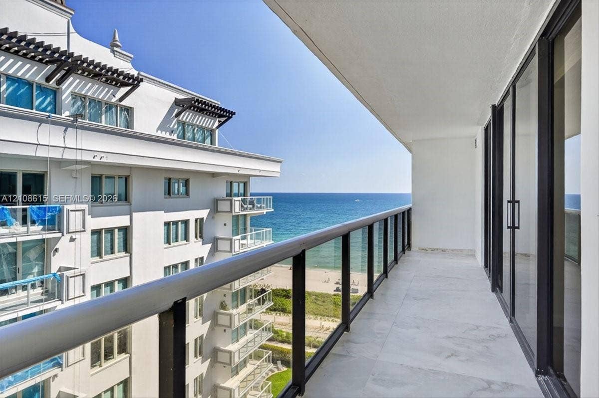 9455 Collins Avenue, #1201, Surfside, FL 33154 Covered balcony featuring oversized tile flooring, full-height glass sliding doors, and a metal-framed glass railing system