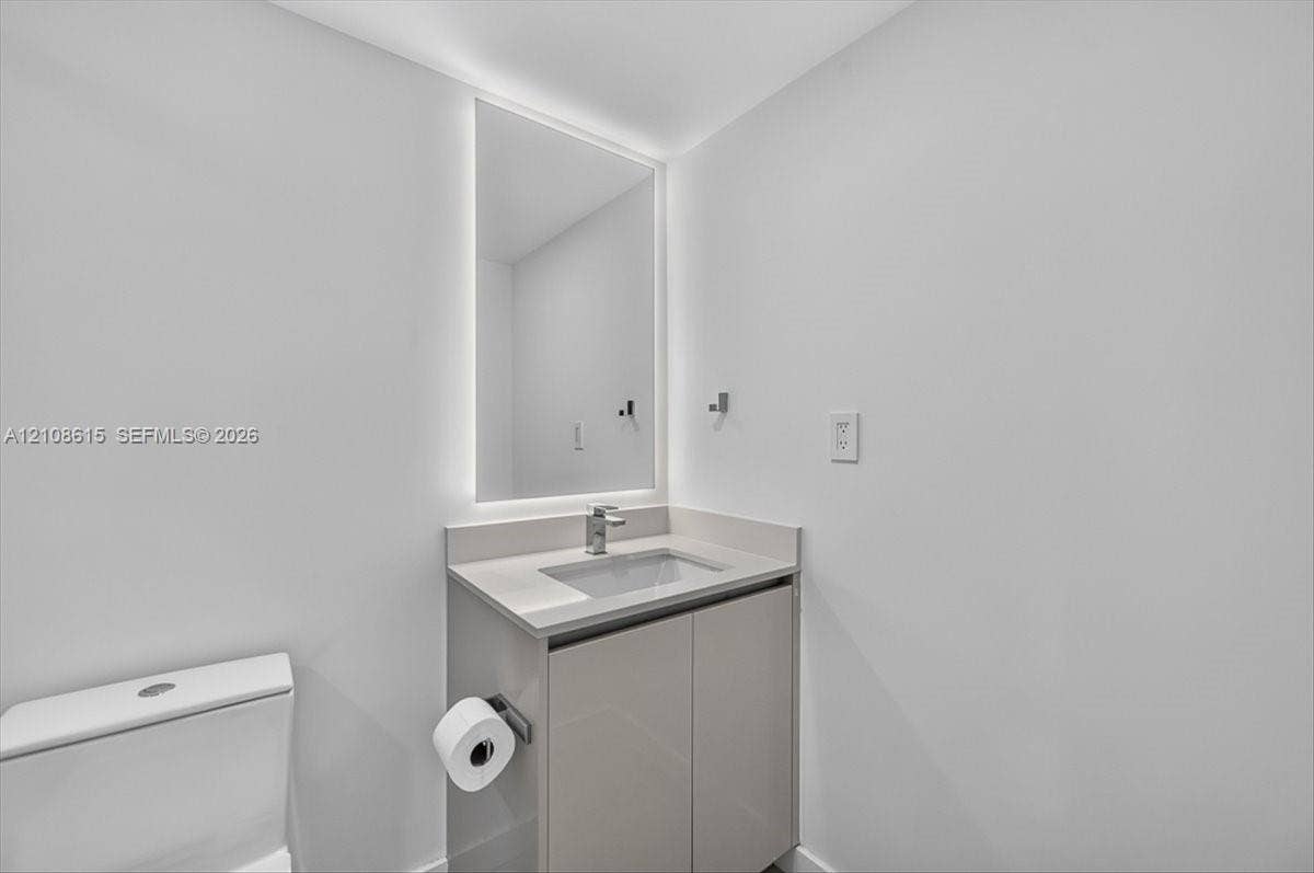 9455 Collins Avenue, #1201, Surfside, FL 33154 Modern vanity with a countertop basin, LED-backlit mirror, and chrome faucet fixture
