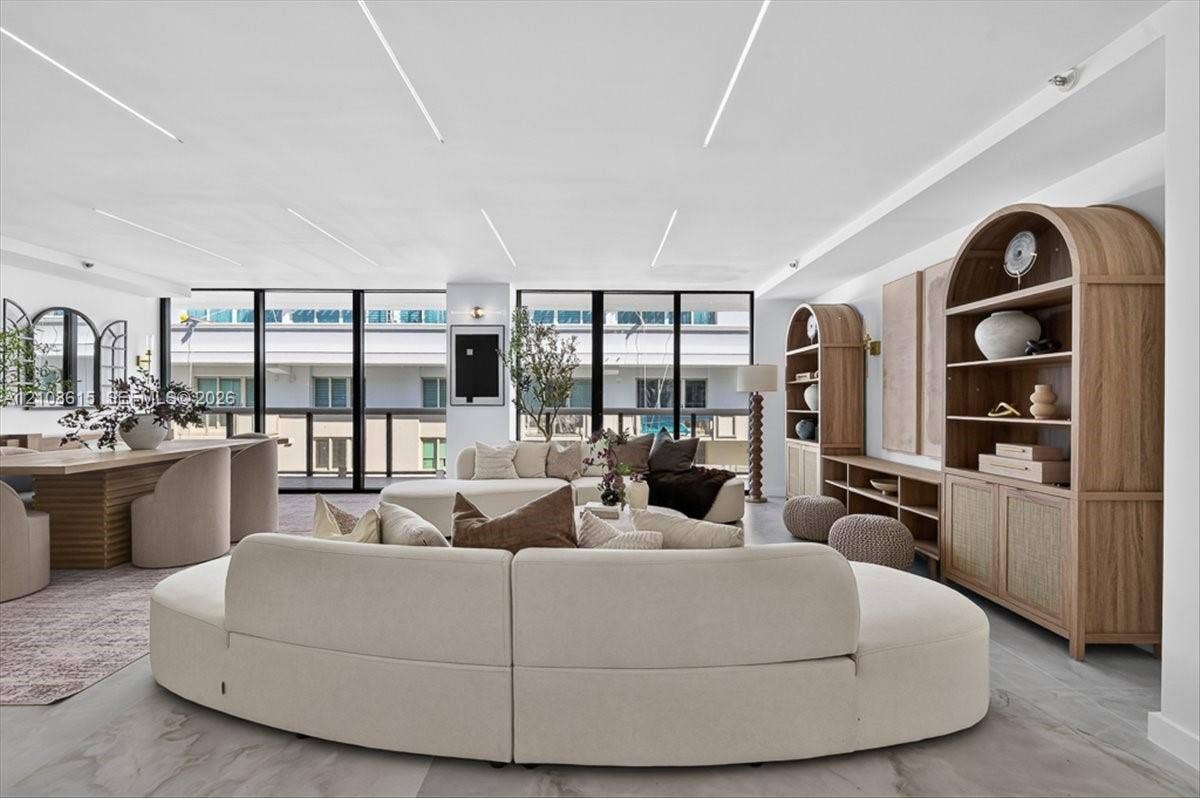 9455 Collins Avenue, #1201, Surfside, FL 33154 Floor-to-ceiling windows, recessed linear ceiling lighting, built-in arched wood cabinetry, and large-format tile flooring