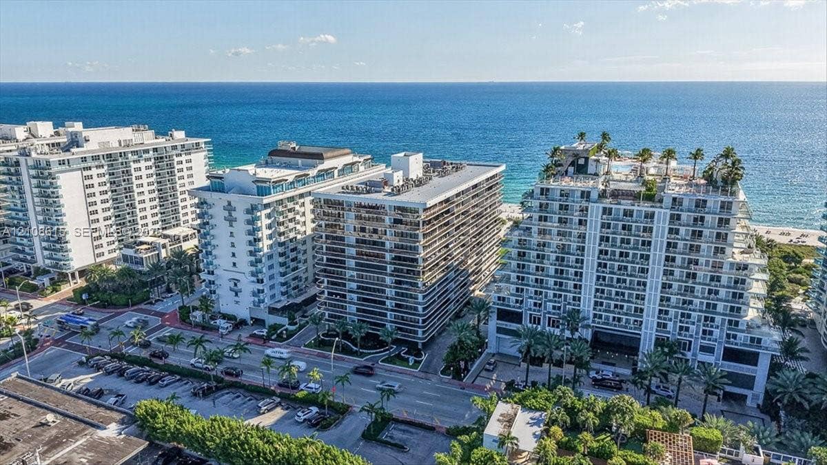 9455 Collins Avenue, #1201, Surfside, FL 33154 Multi-story coastal residential complex featuring private balconies, rooftop landscaping, and direct access to the beach