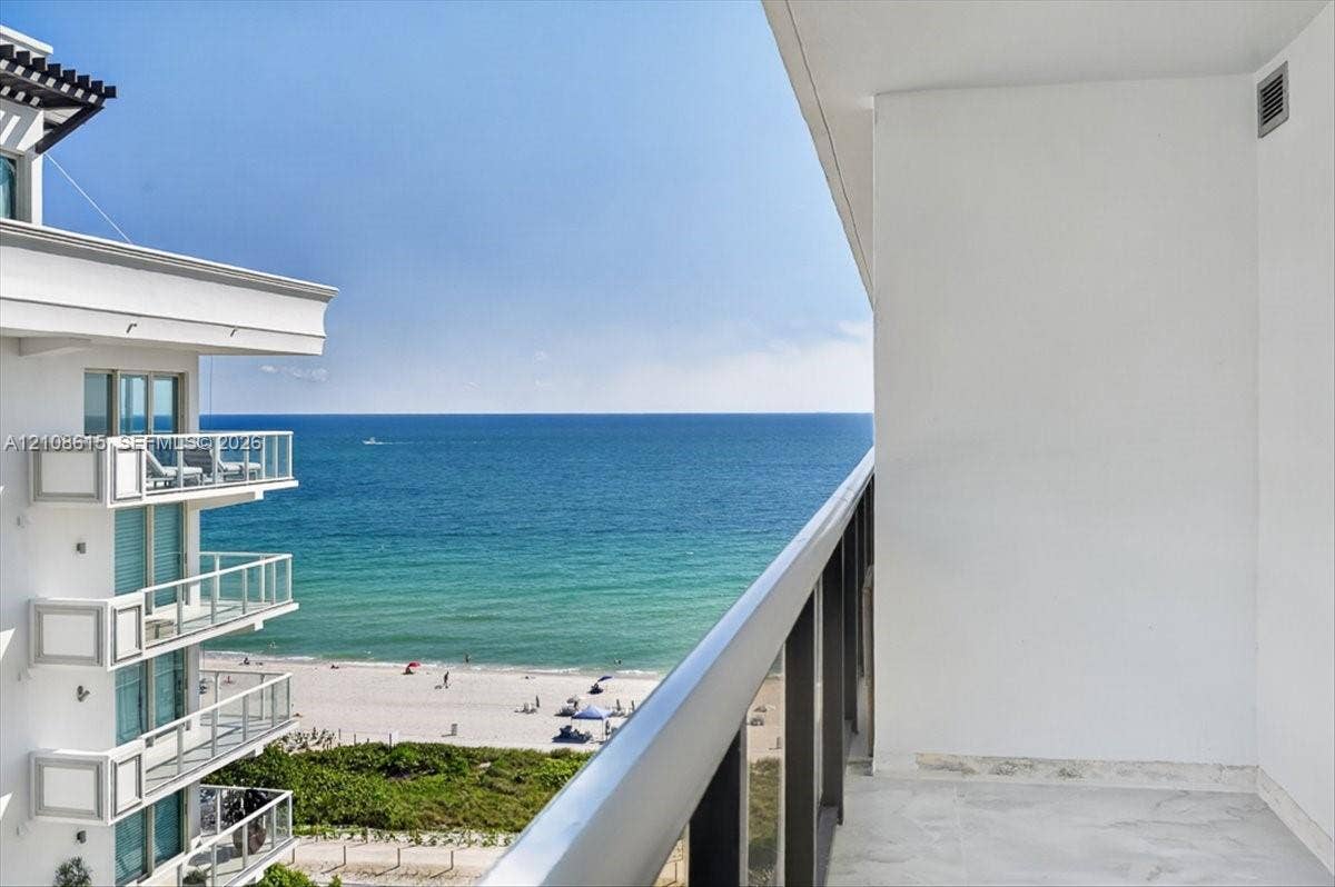9455 Collins Avenue, #1201, Surfside, FL 33154 Private balcony with stone flooring and a glass-paneled railing overlooking the ocean and coastline