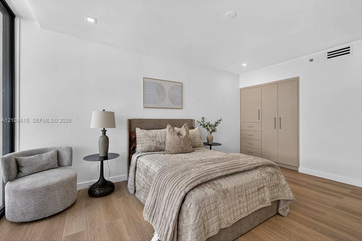 9455 Collins Avenue, #1201, Surfside, FL 33154 Bedroom featuring wood-finish flooring, recessed lighting, and floor-to-ceiling built-in cabinetry with integrated drawer storage